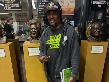 Larry Delmore posing with his portrait.